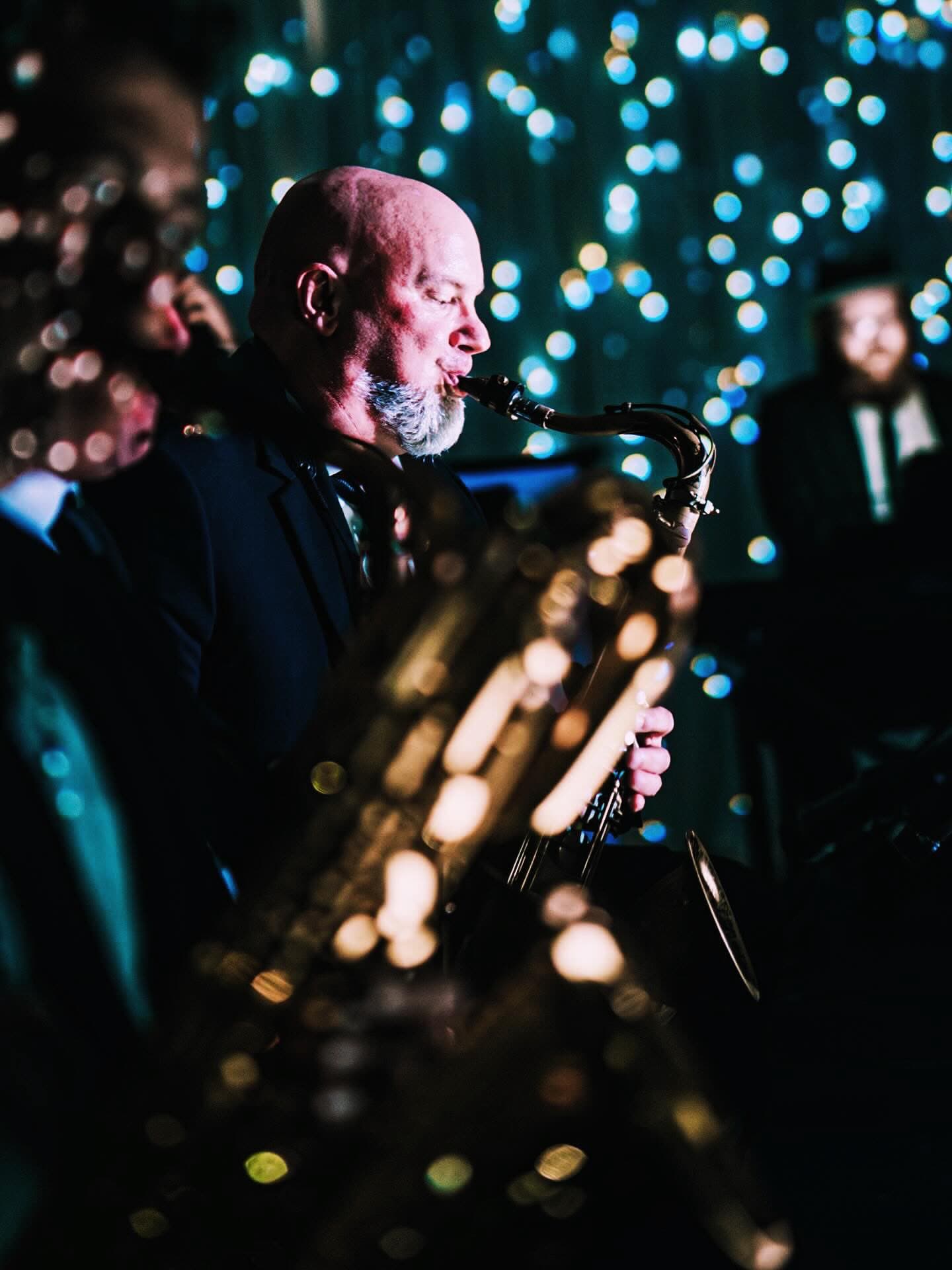 A saxophonist mid-solo, the stars behind him out of focus