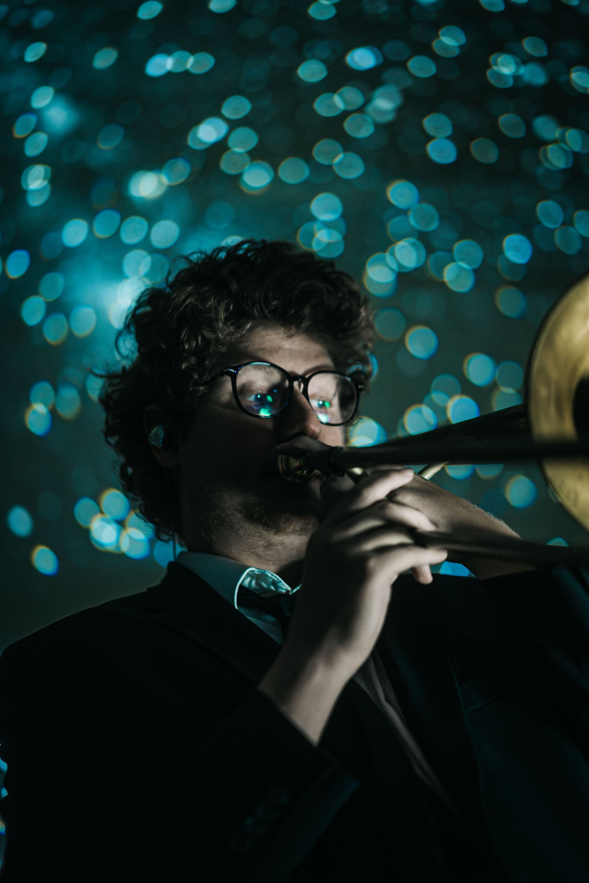 A trombonist playing, stars reflected in his glasses